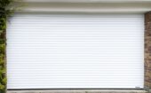 Installation par une petite équipe professionnelle d'une porte de garage motorisée HORMANN enroulable Rollmatic.