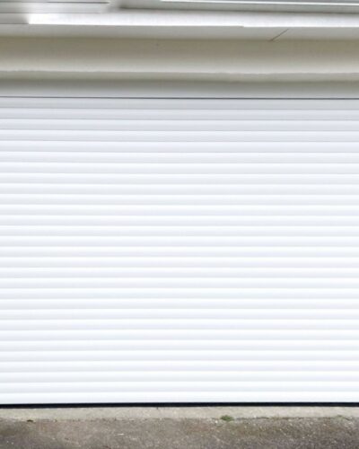 Installation par une petite équipe professionnelle d'une porte de garage motorisée HORMANN enroulable Rollmatic.