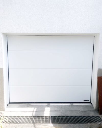 Pose d'une porte de garage Rénomatic de la marque Hormann, rainures L, finition Planar (lisse mat) coloris 9016 Matt deluxe blanc trafic avec motorisation Promatic.
